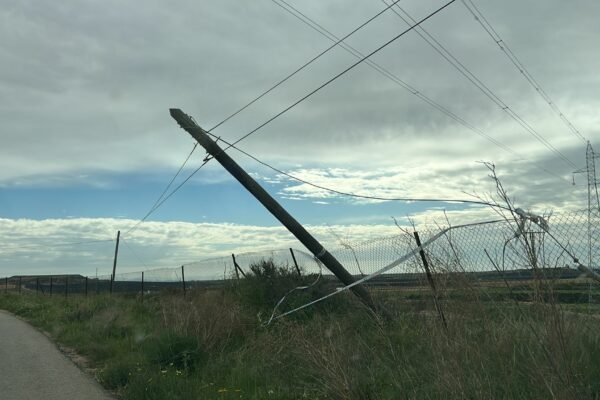 Un poste de cableado volcado y apunto de caer sobre la carretera en las casas del Maestro, Gea y Truyols